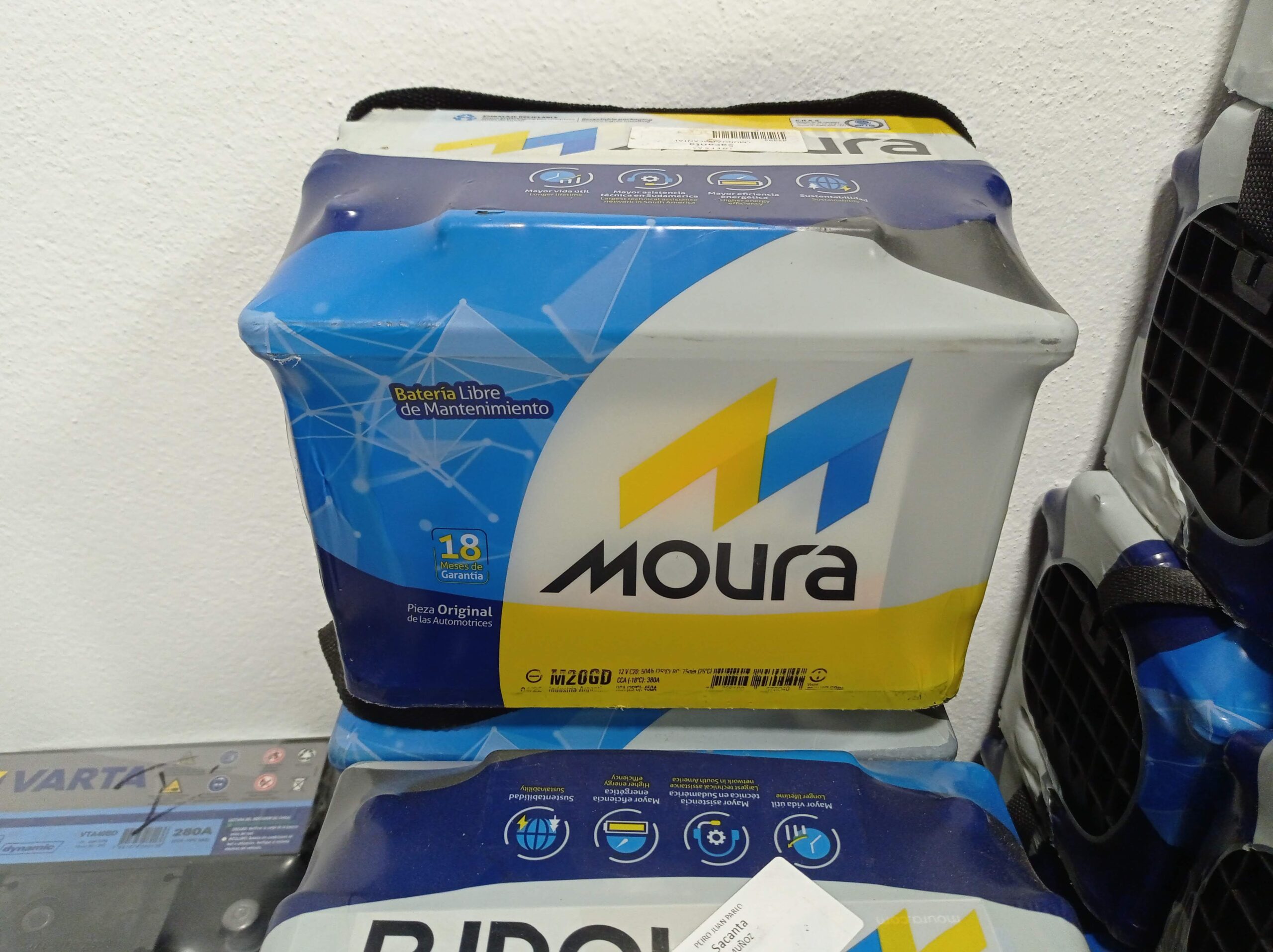 Técnico especialista instalando una batería nueva en auto con diagnóstico de alternador